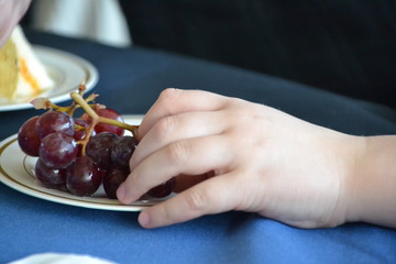 child's hand grabbing grape