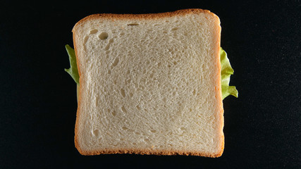 TOP VIEW: A sandwich on a black desk