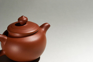 A Chinese purple clay teapot with gray background.