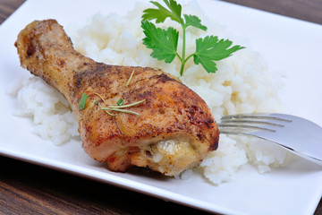 Risotto with chicken leg on table