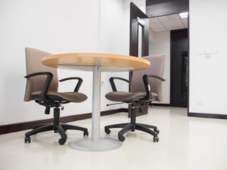 Wide shot of empty meeting room with round table and comfortable chairs ready for meeting or business discussion