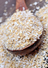 Oat in a spoon on wooden background