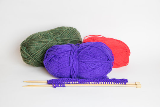 Three Colorful Balls of Yarn with Two Knitting Needles
