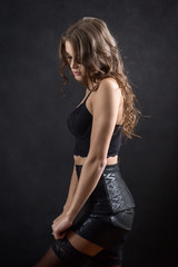 Fototapeta na wymiar luxury young woman undressing on black background