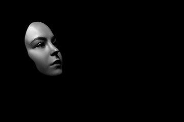 sad female face in hijab on black background with copy space, monochrome