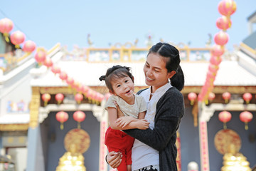 portrait of mother and cute little girl in Yaowarat Road (Bangkok chinatown) at Chinese new year, Bangkok Thailand.