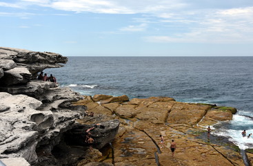 Sydney, Australia - Feb 5, 2017. People relaxing on the rocks of Ray O'Keefe Reserve, North Bondi.