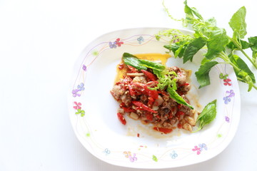 Thai famous fried pork with red chilli and basil leaves on plate on white background,Thai street food, breakfast ,lunch, dinner food, delicious meal 
