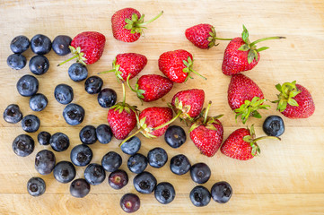 Top view of  fresh strawberries and blueberry on wooden background.