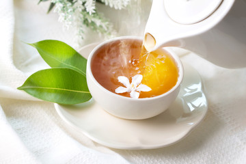 Gros plan versant du thé au jasmin chaud dans une tasse de thé blanc, concept de temps de cérémonie du thé