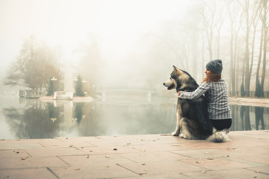 Image of young girl with her dog, alaskan malamute, outdoor