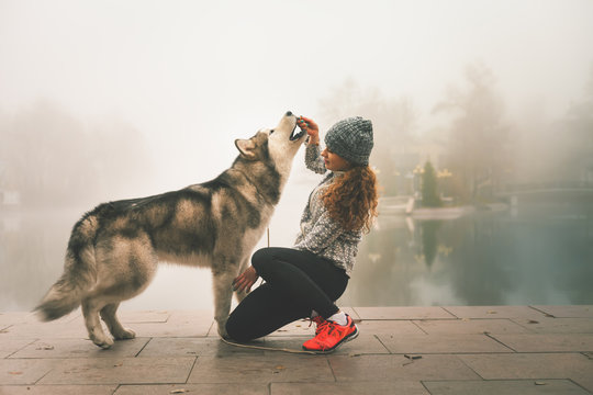 Image of young girl with her dog, alaskan malamute, outdoor