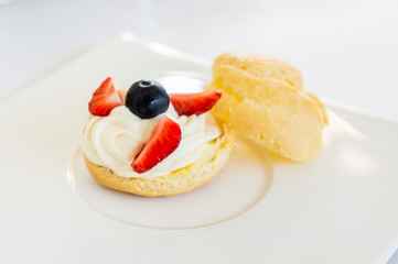 Homemade, Homemade cake, Choux Cream with fresh blueberry and strawberry decorated on white background at house.