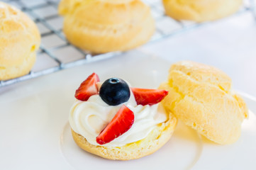 Homemade, Homemade cake, Choux Cream with fresh blueberry and strawberry decorated on white background at house.