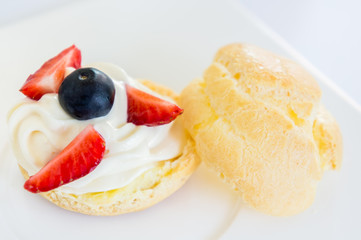 Homemade, Homemade cake, Choux Cream with fresh blueberry and strawberry decorated on white background at house.