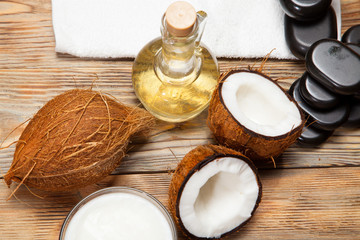 Oil, coconut and stones for a massage on  wooden background