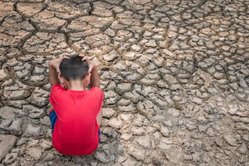 Obraz na płótnie Canvas Sad a child on dry ground, Drought concept.