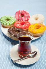 Cup of tea and donuts on a blue table