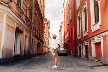 Travel guide. Young female traveler with backpack and with map on the street. Travel concept