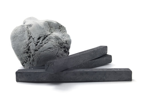 Isolated kneaded eraser with charcoal sticks.