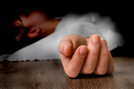 Dead woman lying on the floor under white cloth
