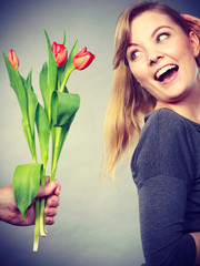 Woman gets bouquet of tulips from man.