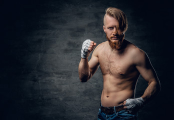 Brutal fighter with long hair over dark grey background.