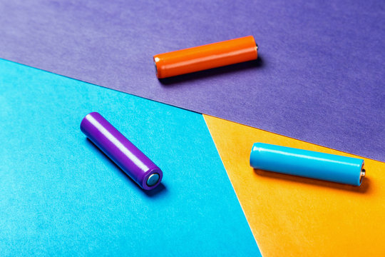 batteries of different color on a colorful background