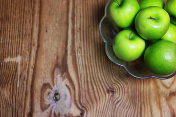 green apple in a glass bowl wooden background