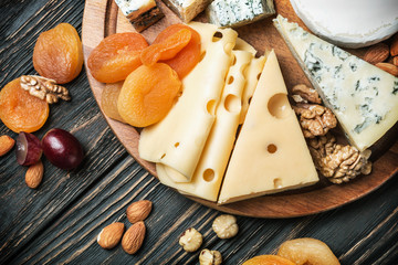 Assorted cheeses with nuts and dried fruits on the table