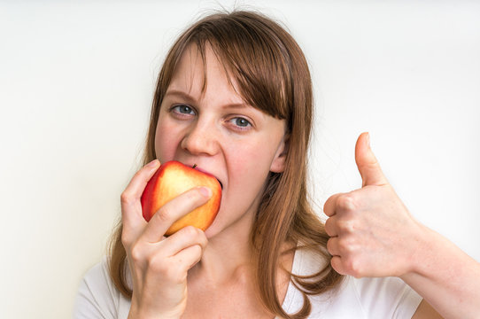 Woman eating an apple isolated on white