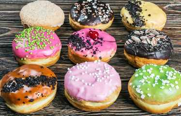 Obraz na płótnie Canvas assorted donuts with different fillings on the wooden table