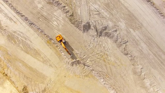 Camera flight over a clay open cast mine with excavators. Heavy industry from above.