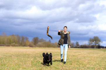 Young woman throwing a stick for her dog to chase