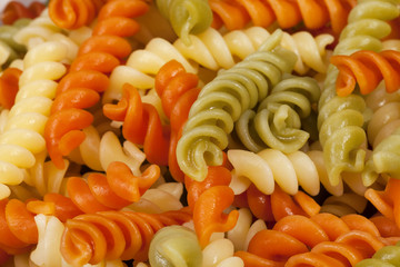 Background of cooked colored spiral pasta