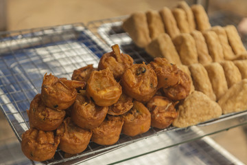 Fried tofu and taro with bean on shelf in street food shop.