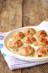 Meatballs in a white sauce. Food Photography. Wooden background.