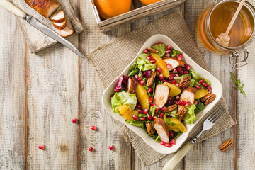 Spring salad with chicken, pomegranate, orange, pecan nuts and honey.