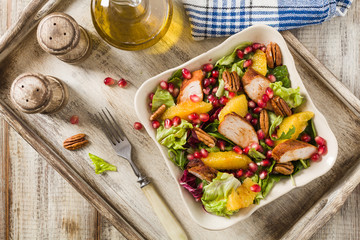 Spring salad with chicken, pomegranate, orange, pecan nuts and honey.