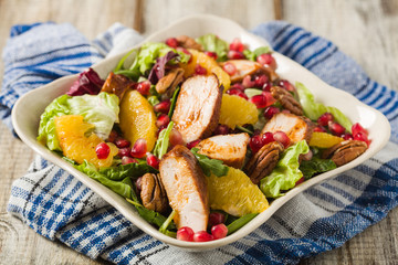 Spring salad with chicken, pomegranate, orange, pecan nuts and honey.