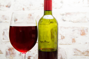 Bottle of red wine with glass ready to pour