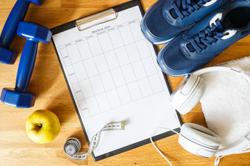 Personal workout plan with sneakers, headphones and dumbbells. Top view image