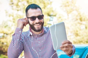Fototapeta premium Young man listening music in a city park