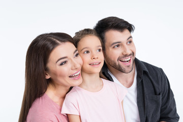 Happy young family with one child looking away on white