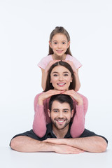 Happy young family with one child looking at camera on white