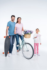 smiling family with skateboard and bicycle on white