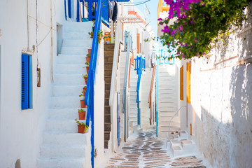Traditional houses with blue doors and stairs in the narrow streets of greek village