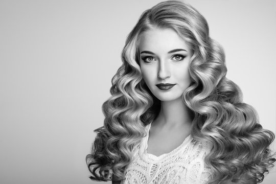 Black and white photo of beautiful woman with elegant hairstyle. Blonde woman with curly hairstyle. Perfect make-up. Fashion photo