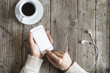 Woman using mobile phone on wooden table
