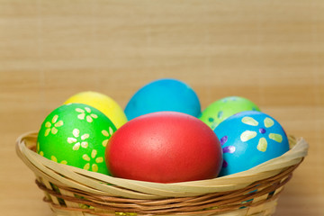 Obraz na płótnie Canvas Colored eggs in basket